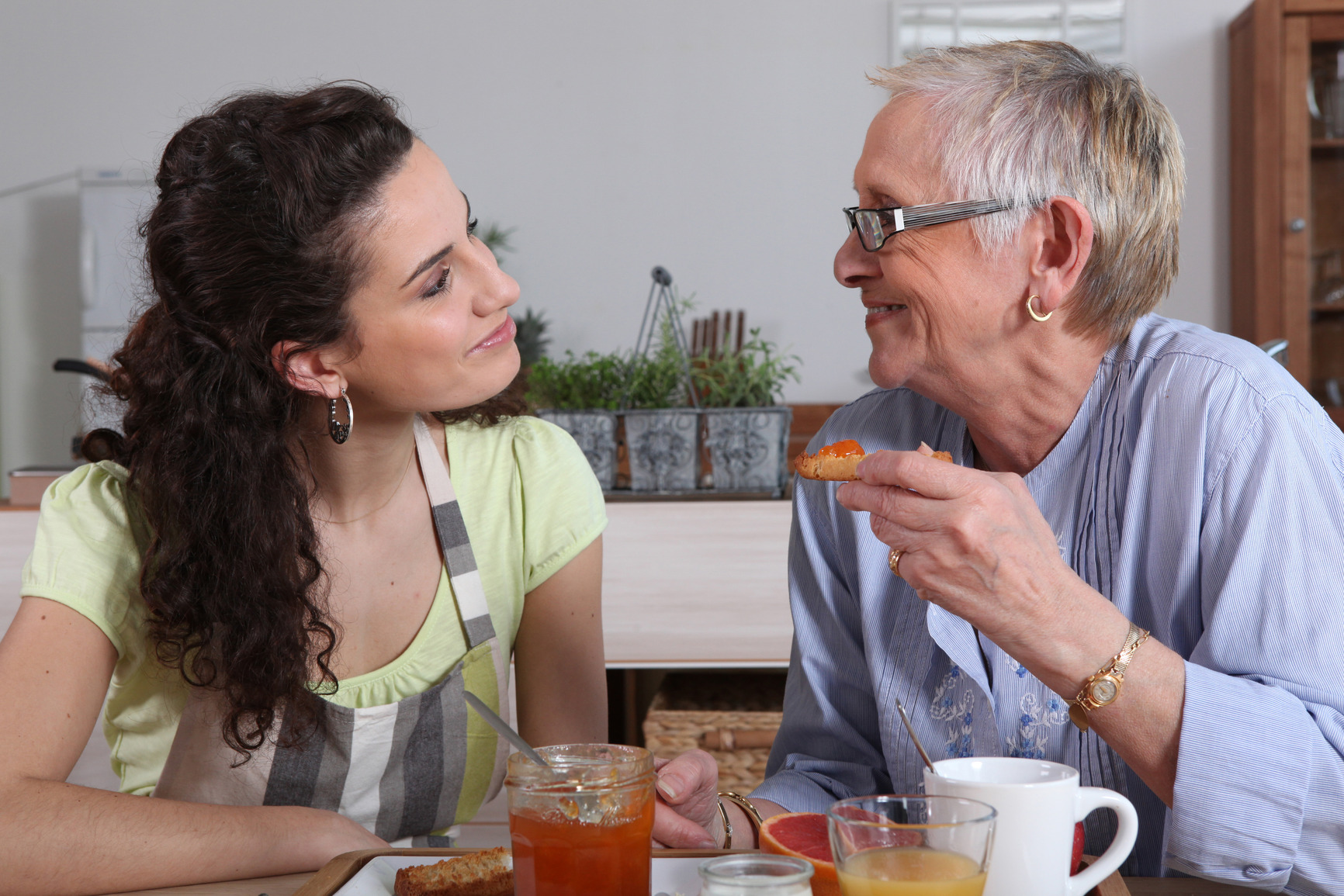 Caregiver eating with elderly woman